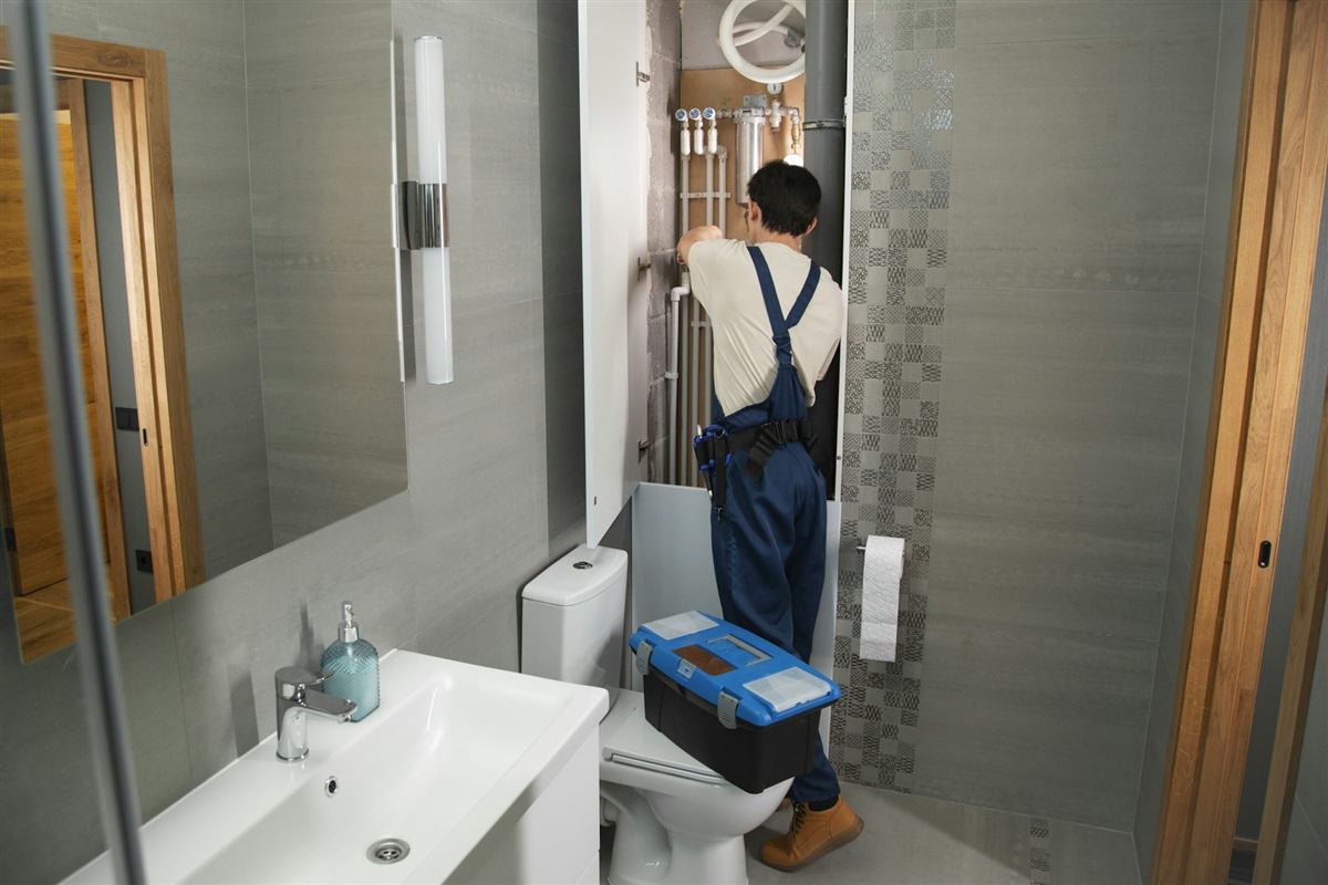 Majstor radi na instalacijama iza WC šolje — otpušavanje WC šolje u Nišu
